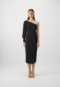 Svart midi-kjole med asymmetrisk design på den ene skulderen og ballongslette. Laget av glatt stoff, med en tettsittende midje og drapert detalj.