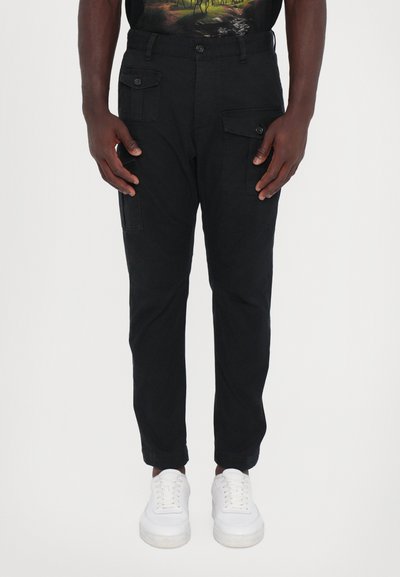 Schwarze Cargo-Hosen aus Baumwolle mit geradem Schnitt, ausgestattet mit mehreren Seitentaschen und einem Knopfverschluss an der Taille.