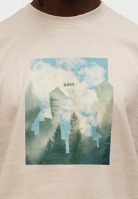 Ανοιχτό μπεζ μπλουζάκι με γραφικό τύπωμα στυλιζαρισμένων δέντρων και ορίζοντα με σύννεφα, με υφή και πολυεπίπεδο σχέδιο, με ετικέτα "BOSS".