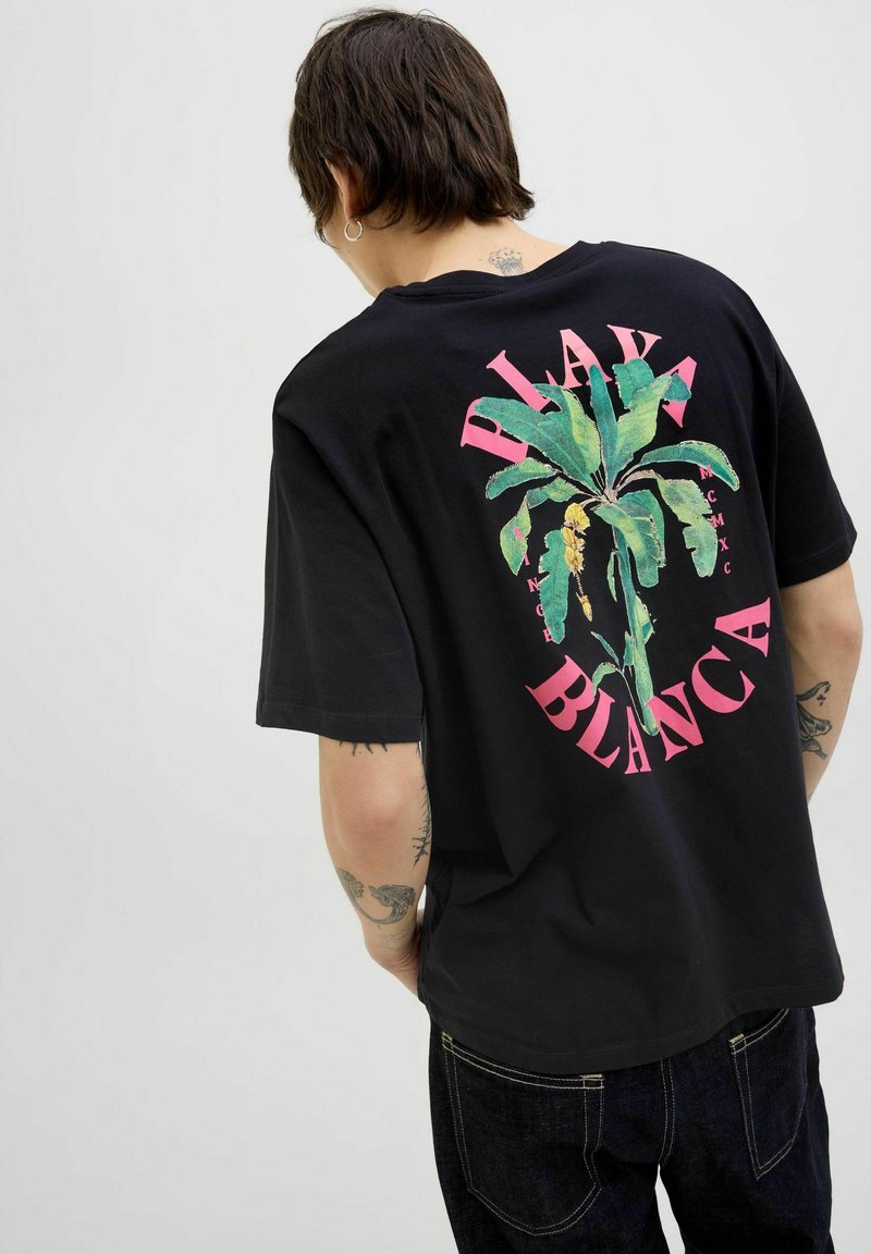 Sort bomulds t-shirt med et levende grønt plante design og pink tekst "Playa Blanca" på ryggen samt en afslappet pasform.