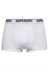 Boxers blancos hechos de tela suave; cuentan con una cinturilla elástica negra con "SUPERDRY" impreso en texto blanco. Textura suave, diseño ajustado.