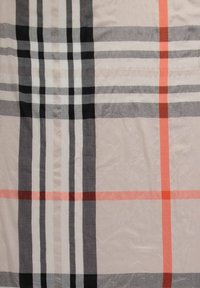 Tissu beige avec un motif à carreaux composé de larges rayures verticales et horizontales noires, grises, blanches et orange.