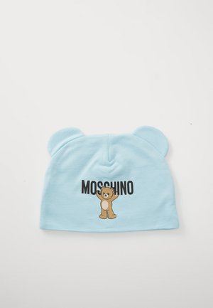 Gorro azul claro com orelhas de urso, apresentando um gráfico de um urso a acenar e o texto "MOSCHINO" abaixo.