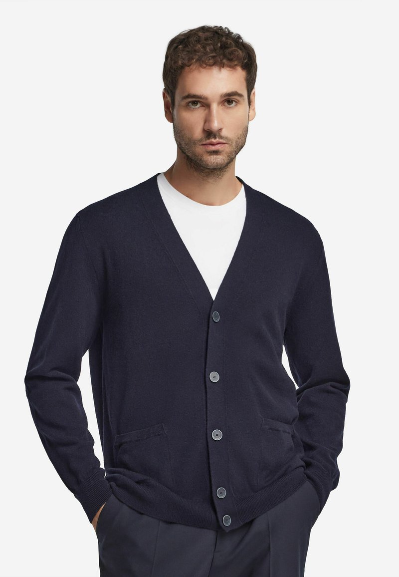 Mörkblå stickad cardigan med V-krage, fem knappar och två framfickor, med en mjuk textur och ribbade mudd och nederkant.