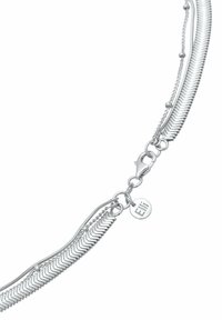 Bracelet en chaîne argentée présentant plusieurs brins avec des motifs en zigzag et une petite étiquette ronde gravée "Elli". Fermeture à clip.