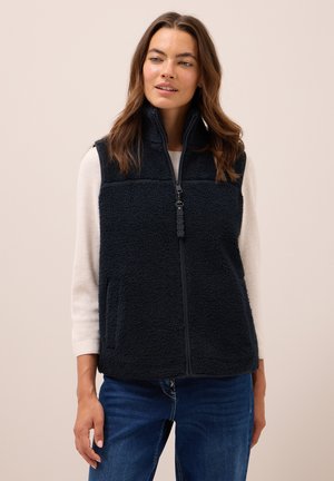 Gilet en polaire bleu marine avec un col montant, fermeture éclair et deux poches latérales ; le tissu texturé crée une apparence chaleureuse et confortable.