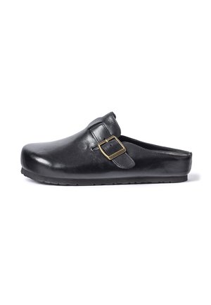 Zueco de piel negro sin cordones con hebilla de latón ajustable y suela de goma plana, mostrado de lado sobre un fondo blanco.