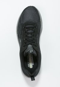 Černá atletická obuv Skechers s pleteným svrškem, šněrovacím designem, stélkou z paměťové pěny a gumovou podrážkou zobrazená z horního pohledu na bílém pozadí.