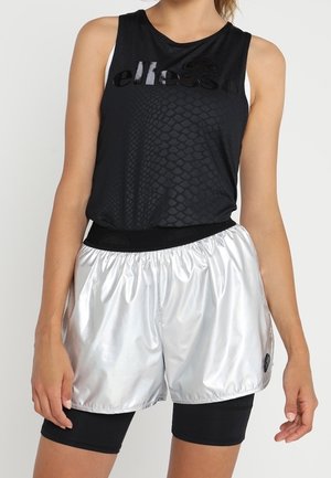 Zwart mouwloos sporttop met een textuurpatroon, gecombineerd met glanzende zilveren shorts met een elastische tailleband en logo-detail.