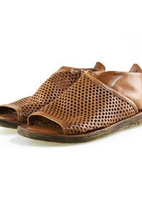 Sandales en cuir marron avec des découpes en forme de nid d'abeille, orteils ouverts et semelles en caoutchouc légèrement usées sur fond blanc.