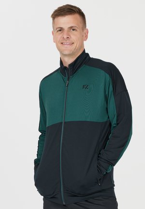 Sort og grøn sportsjakke med lynlås foran, der har et struktureret øverste panel og en ensfarvet nederste sektion. Fremhævet med FZ-logoet.