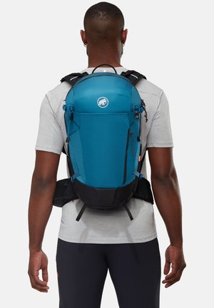 Mochila de senderismo en color verde azulado con base negra, correas acolchadas y almacenamiento exterior. Presenta un logo en la parte frontal y detalles de cierre ajustables.