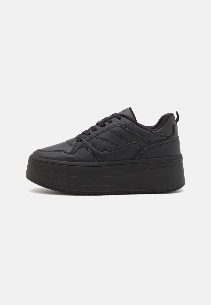 Black platform sneakers made of textured leather, featuring a rounded toe, lace-up front, and a pull tab at the heel for easy wear.