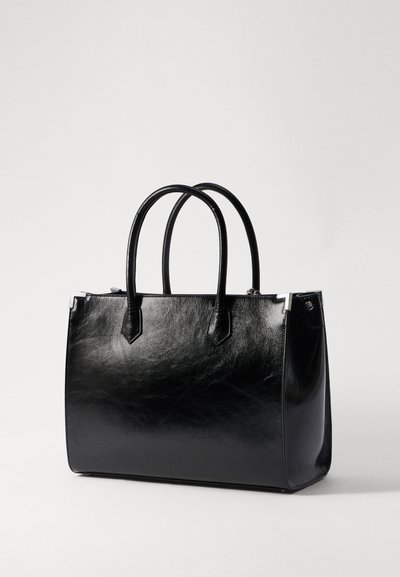 Sac fourre-tout en cuir noir avec une finition brillante, deux poignées arrondies, des accents en métal argenté angulaires et une forme rectangulaire structurée.