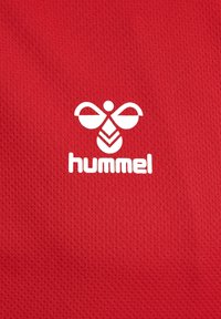 Rød struktureret stof med et fremtrædende hvidt logo af en stiliseret bi med teksten "hummel" under.