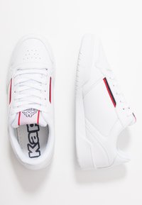 Weiße Sneakers aus glattem Leder, mit perforierter Zehenkappe, roten und marineblauen Akzenten an den Seiten sowie einer strukturierten Gummisohle.