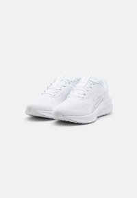 Une paire de baskets de sport blanches avec des dessus en mesh, un design à lacets, des semelles rembourrées et un logo de marque sur les côtés, le tout sur un fond uni.