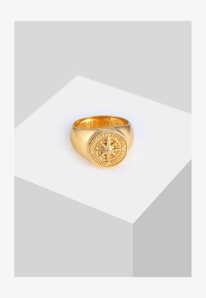 Bague en or présentant un design de boussole proéminent avec des détails complexes. Fini lisse, bande arrondie et nom de marque gravé à l'intérieur.