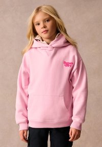 Felpa rosa realizzata in tessuto morbido, con tasca frontale, cappuccio con coulisse e logo "Super Dry" di un vivace rosa sul petto.