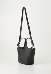 Sac fourre-tout en cuir noir avec une surface texturée, des poignées doubles et une longue sangle réglable. Accents en métal doré aux attaches.