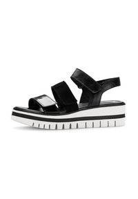 Zwarte platform sandalen met twee verstelbare banden. Glanzende en matte afwerkingen, voorzien van een chunky witte zool met zwarte strepen en een getextureerde loopzool.