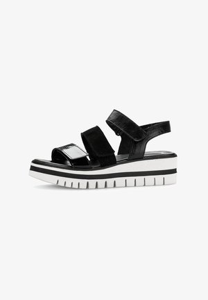 Schwarze Plateausandalen mit zwei verstellbaren Riemen. Glänzende und matte Oberflächen, ausgestattet mit einer klobigen weißen Sohle mit schwarzen Streifen und strukturiertem Profil.