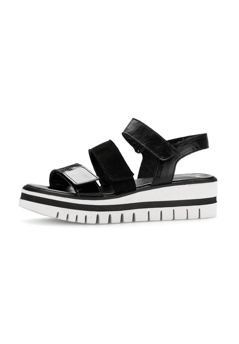 Zwarte platform sandalen met twee verstelbare banden. Glanzende en matte afwerkingen, voorzien van een chunky witte zool met zwarte strepen en een getextureerde loopzool.