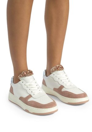 Sneaker bianchi e rosa con rivestimento in suede testurizzato, tacco metallico e dettaglio gioiello alla caviglia. Presentano suole piatte e design con lacci.