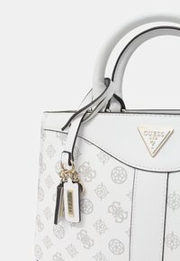 Borsa bianca con finitura testurizzata, caratterizzata da delicati motivi logo grigi, accessori in oro e manici doppi. Include un charm e un'etichetta.