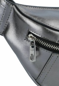 Metaliczna szara nerka z zamkiem błyskawicznym, czarną taśmą zamknięcia i srebrnymi elementami. Gładka tekstura z wyraźnymi detalami stębnowania.