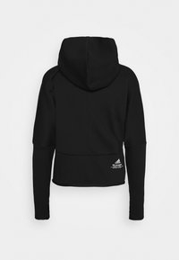 Sweat à capuche noir à manches longues avec grande capuche, coupe slim et petit logo Adidas blanc avec texte en bas à droite du dos.