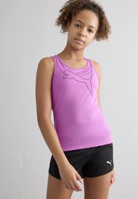 Top atlético rosa com um logótipo preto da Puma, combinado com calções pretos. O tecido parece suave e elástico, projetado para vestuário ativo.