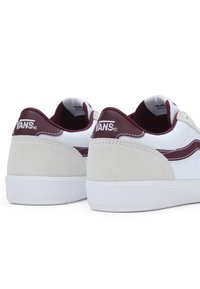 Sneaker Vans bianchi e bordeaux in materiali scamosciati e tessili, forma tondeggiante, suole in gomma, e logo sul tallone e sul lato.