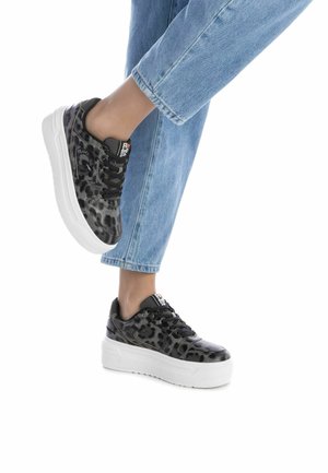 Zapatillas de plataforma con estampado de leopardo en negro y gris, con parte superior de cuero texturizado y suela de goma blanca, atadas con cordones negros.