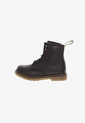Bottine noire en cuir à lacets avec semelle épaisse surpiquée en jaune et languette à l'arrière.