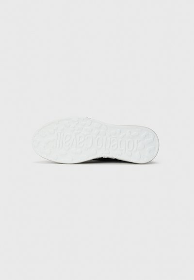 White rubber sneaker sole with textured grip pattern and raised brand logo. Smooth, curved edges with a rounded toe design.