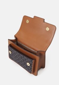 Torebka ze skóry w kolorze brązowym ma niebieską wzorzystą kieszeń z przodu. Wnętrze zawiera dodatkowe przegrody o gładkiej fakturze. Złote akcenty.