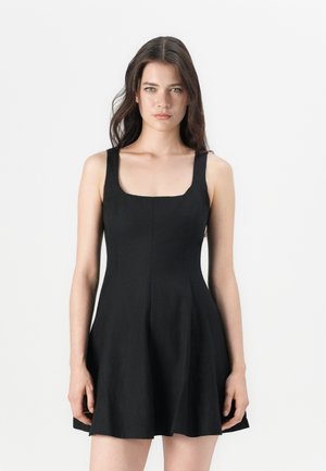 Robe noire sans manches avec un décolleté carré, corsage ajusté et jupe évasée. Fabriquée en tissu lisse, elle présente des détails de couture subtils.