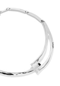 Collar de metal plateado con un diseño suave y curvado. Presenta segmentos alargados e interconectados con un acabado pulido. Marcado con "UNO de 50."