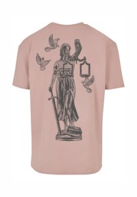 Camiseta de algodón rosa con un gráfico negro de una figura femenina sosteniendo balanzas y una espada, rodeada de palomas voladoras en la espalda.