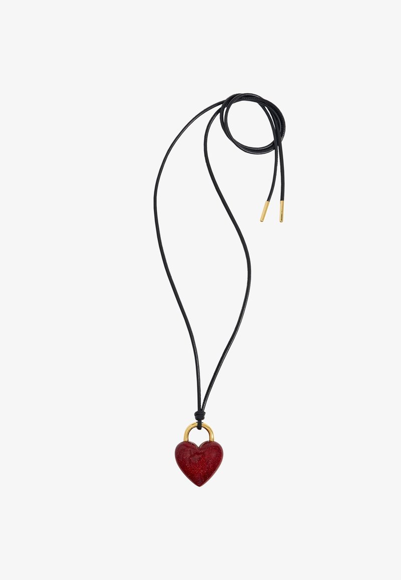 Collier en corde noire avec un pendentif rouge brillant en forme de cœur maintenu par une petite boucle en or et des extrémités de corde dorées.
