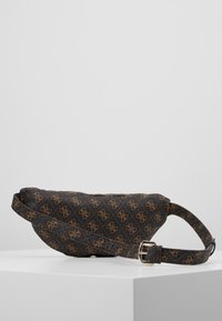 Banane noire à motif en matériau synthétique avec un logo brun imprimé et une sangle réglable équipée d'une boucle métallique.