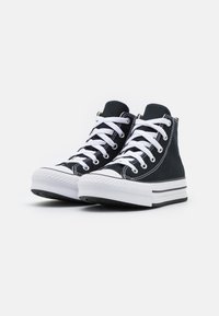 Pair of black high-top canvas sneakers with white laces and thick white rubber soles on a plain white background.