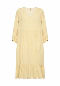 Robe jaune avec un décolleté en V, de longues manches bouffantes et un ourlet à volants en cascade. Le tissu présente un motif en zigzag subtil. Coupe décontractée et fluide.