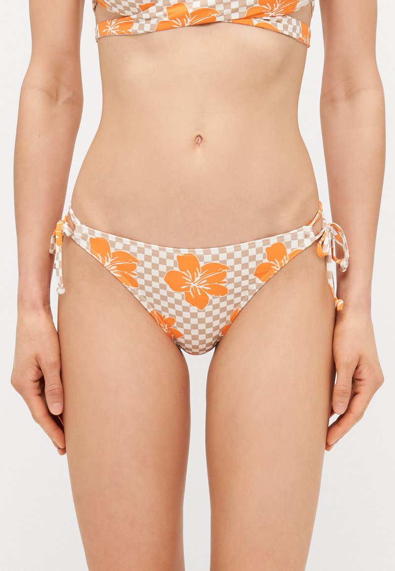 Virágmintás bikini alsó, narancsszínű virágokkal egy kockás bézs háttéren. Oldalt megkötős, sima textúrával.