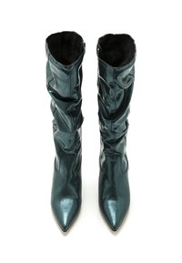 Bottines métalliques teal à bout pointu et design flou, avec une texture douce et une doublure intérieure noire. Fermeture éclair sur le côté.