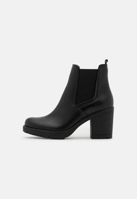Schwarze Chelsea-Stiefelette aus glattem Leder, mit elastischen seitlichen Einsätzen, einer Zuglasche und einem robusten Blockabsatz. Strukturierte Gummisohle.