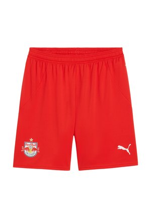 Rote Sportshorts aus leichtem Stoff. Elastischer Bund, zwei Seitentaschen, mit dem Logo von 'Red Bull Salzburg' und dem Puma-Logo in Weiß.