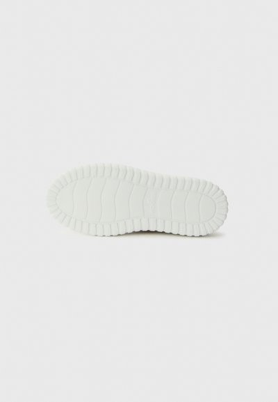 Semelle d'une sneaker, en matériau caoutchouteux blanc avec une surface texturée et des bords incurvés et striés pour une meilleure adhérence.
