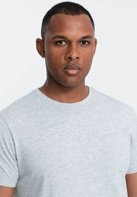Grå kortærmet t-shirt lavet af blødt stof. Har en klassisk rund halsudskæring og en subtil tekstur. Velegnet til afslappet brug.